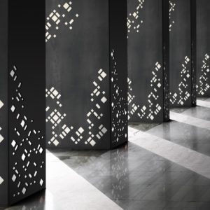 Row of columns with sunlight in the gaps and reflected in shiny floor